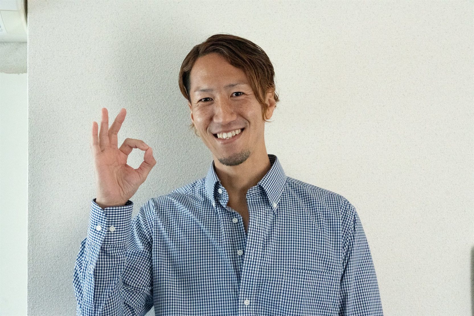 笑顔でOKサインを見せる佐藤トレーナー